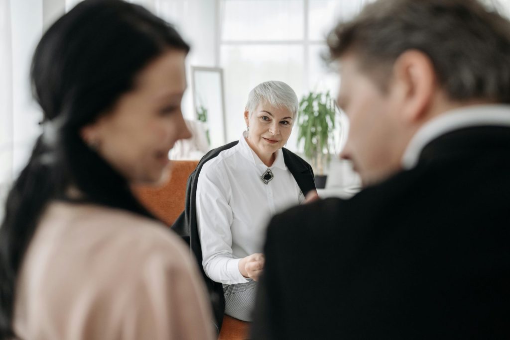 A professional consultation session with a couple and a social worker in a modern office environment.